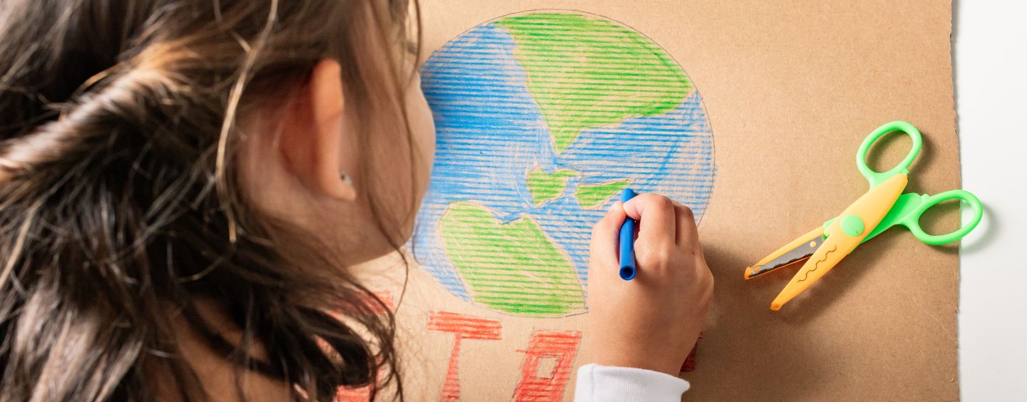 Child coloring a picture of Earth