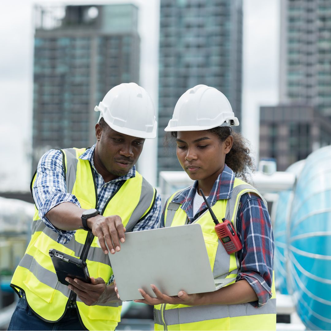 Pair of construction professioals looking at laptop