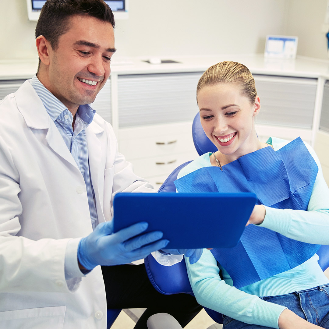 Dental assistant shows something to his patient