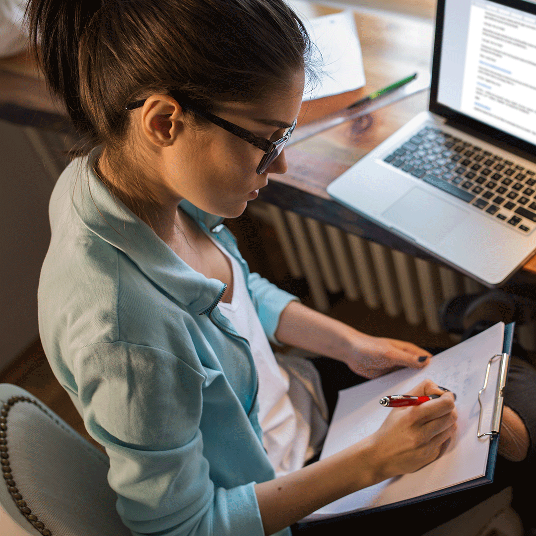 E-Learning instructional designer works on paper and laptop