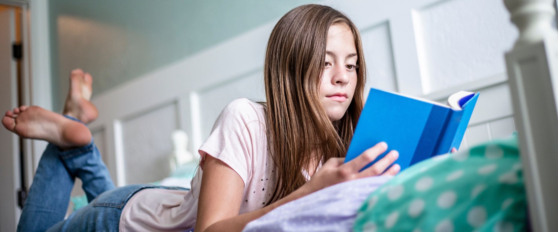 Girl reads while lying down