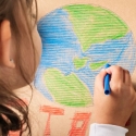 Child coloring a picture of Earth