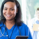 Medical assistant holding iPad in hospital hallway