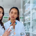 Two pharmacists read medication bottle