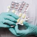 Pharmacy tech wearing gloves while holding pills