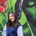 International student poses in front of Tupac mural