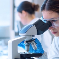 Clinical lab scientist looking into microscope