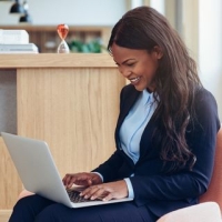 Smiling professional woman uses laptop