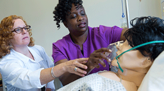 CMA student and teacher administer oxygen on medical dummy